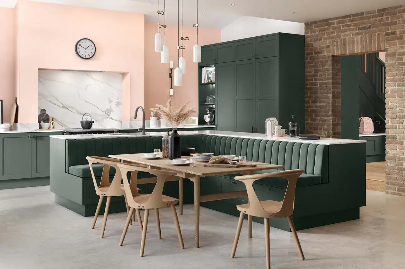 Shaker-style kitchen with integrated seating area painted heritage green