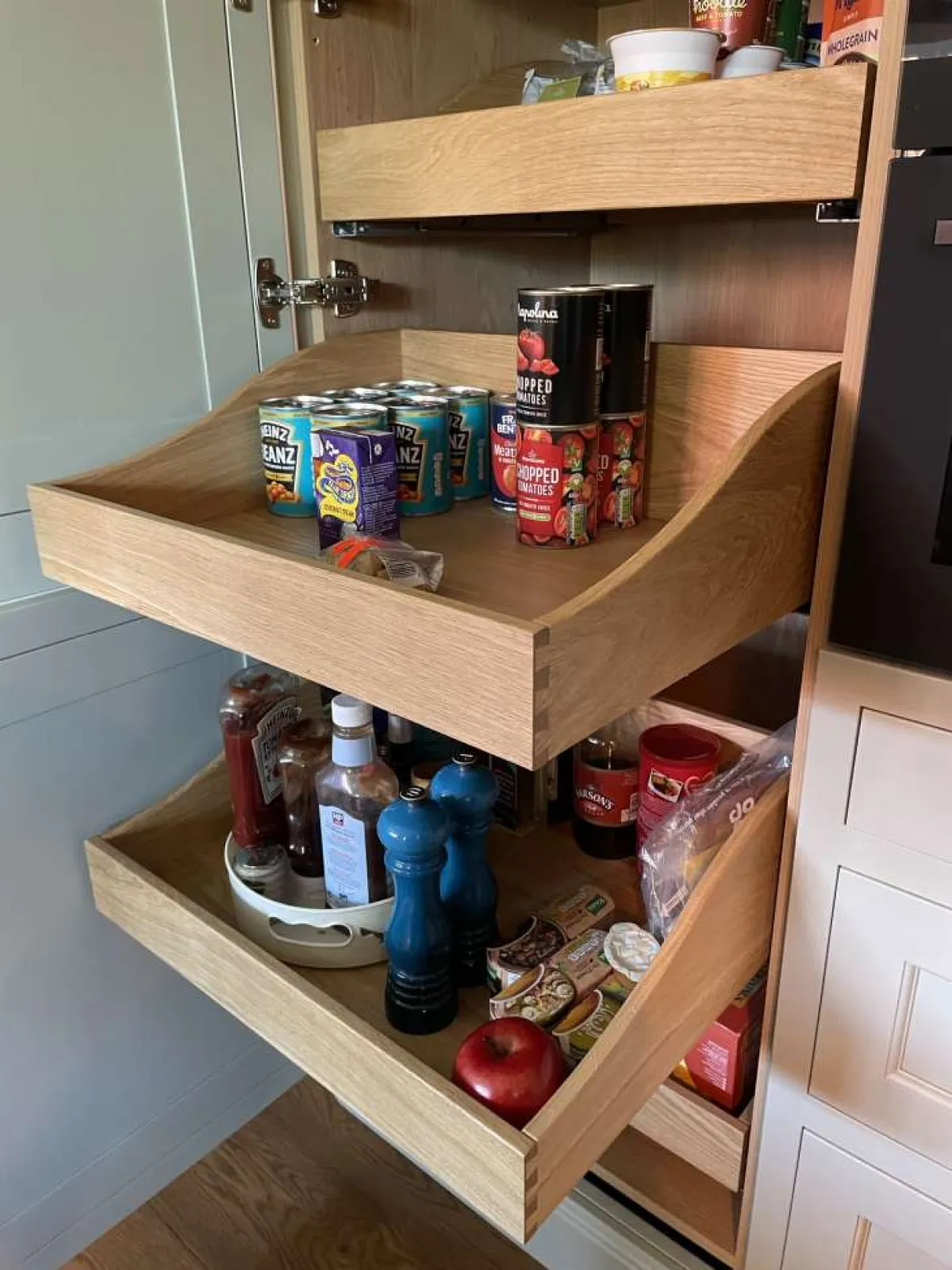 In-frame shaker-style kitchen larder unit with pull-out drawer in light oak finish