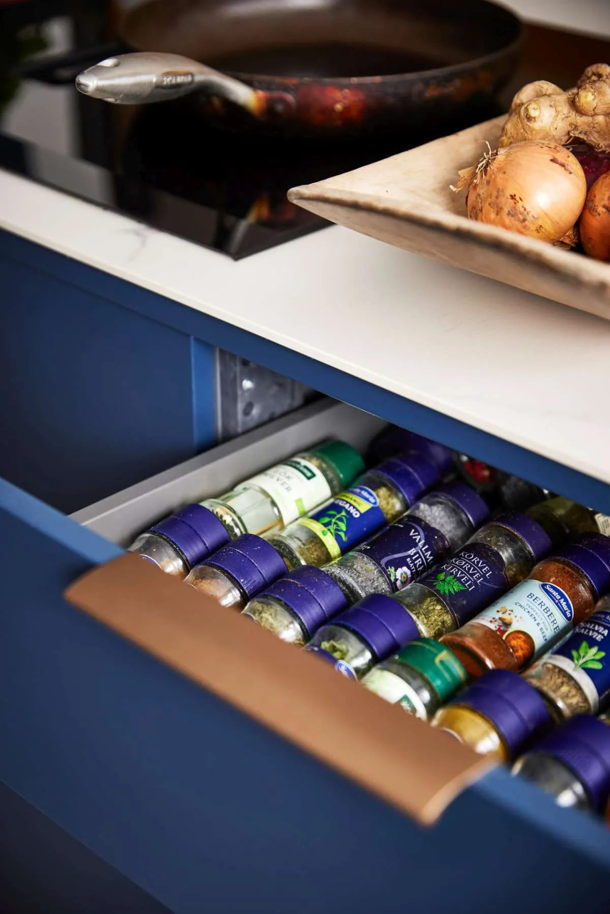 Modern style blue kitchen showing spice bottle drawer insert