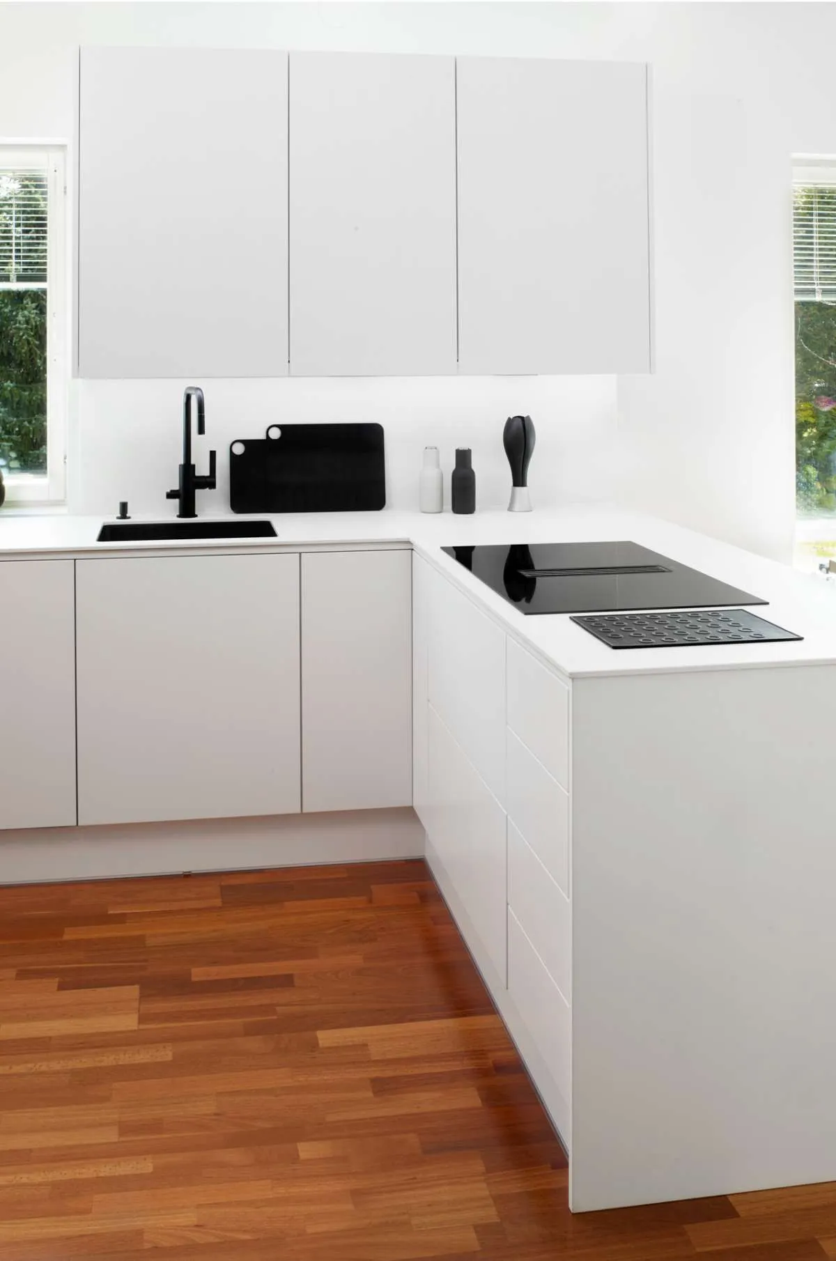 Scandi style Puustelli Miinus white kitchen showing black sink, tap, and hob