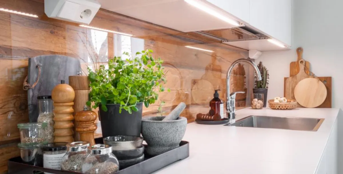 White kitchen with reflective backsplash, under cabinet lighting and a dish-draining cabinet